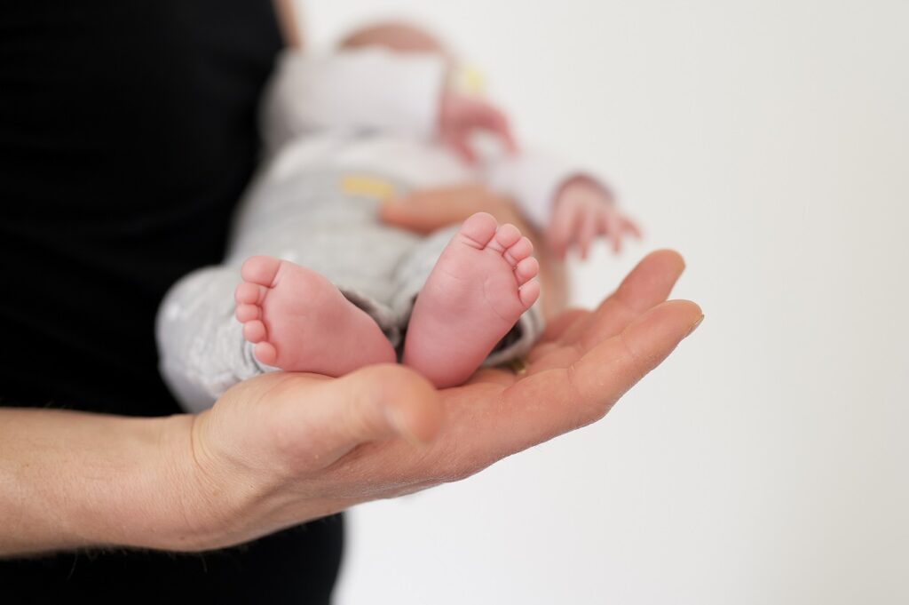 selective focus shot person carrying newborn baby
