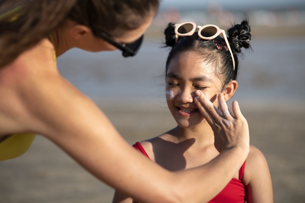 woman applying sunscreen kid front view
