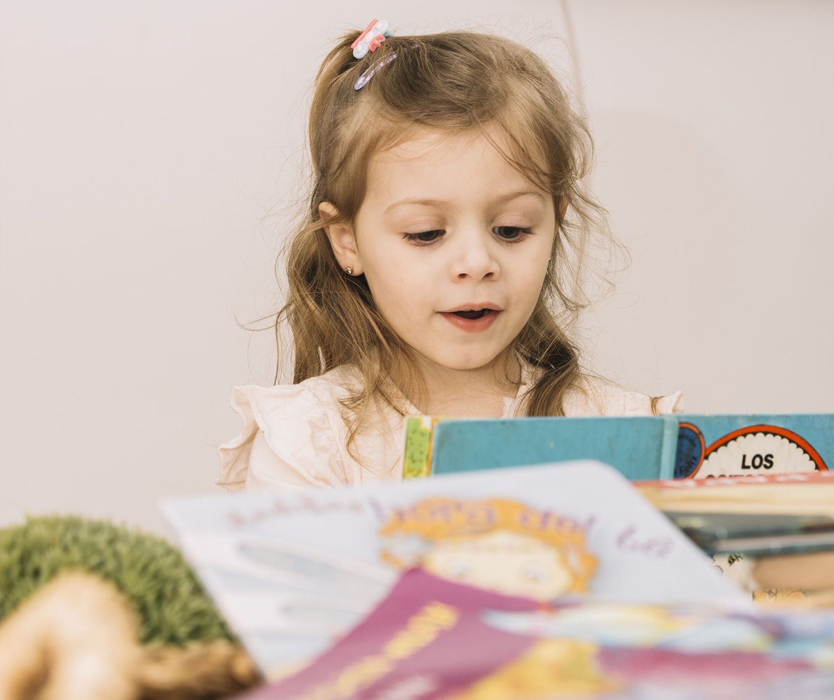 doce menina lendo na mesa