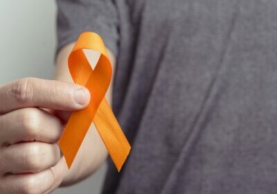 Man showing orange ribbon. Awareness ribbon.