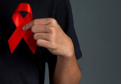 Men holding red ribbons. Conceptual awareness. HIV. World AIDS Day and World Sexual Health Day.
