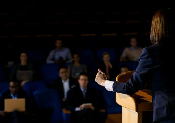 vista-traseira-executivo-de-negocios-feminino-dando-um-discurso